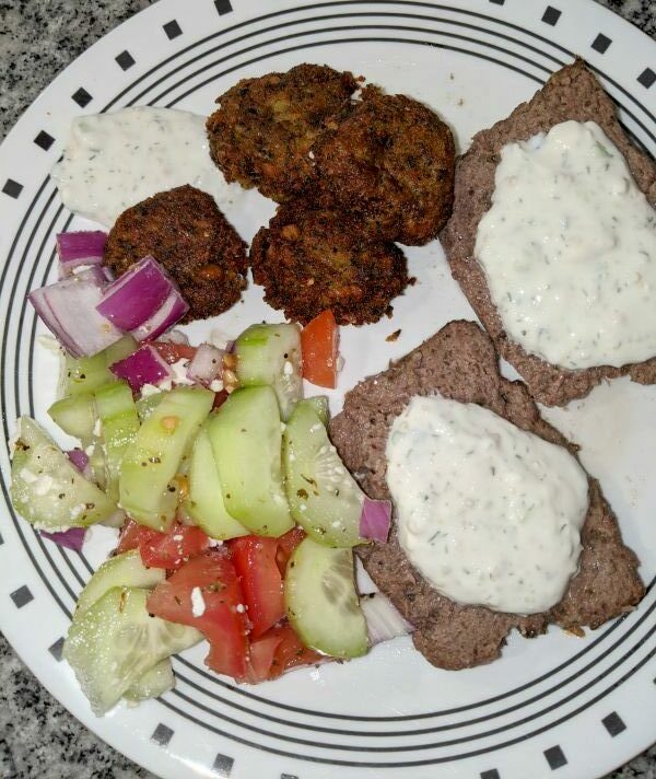 Plate containing Greek Cucumber Salad, Falafel, Tzatiki Sauce, and Lamb and Ground Beef Gyros